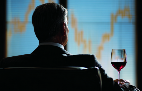Enthusias An investor sitting in front of a glass of red wine b7ed6b8a 23e5 4fbc a6c4 cb803d797ad7 3